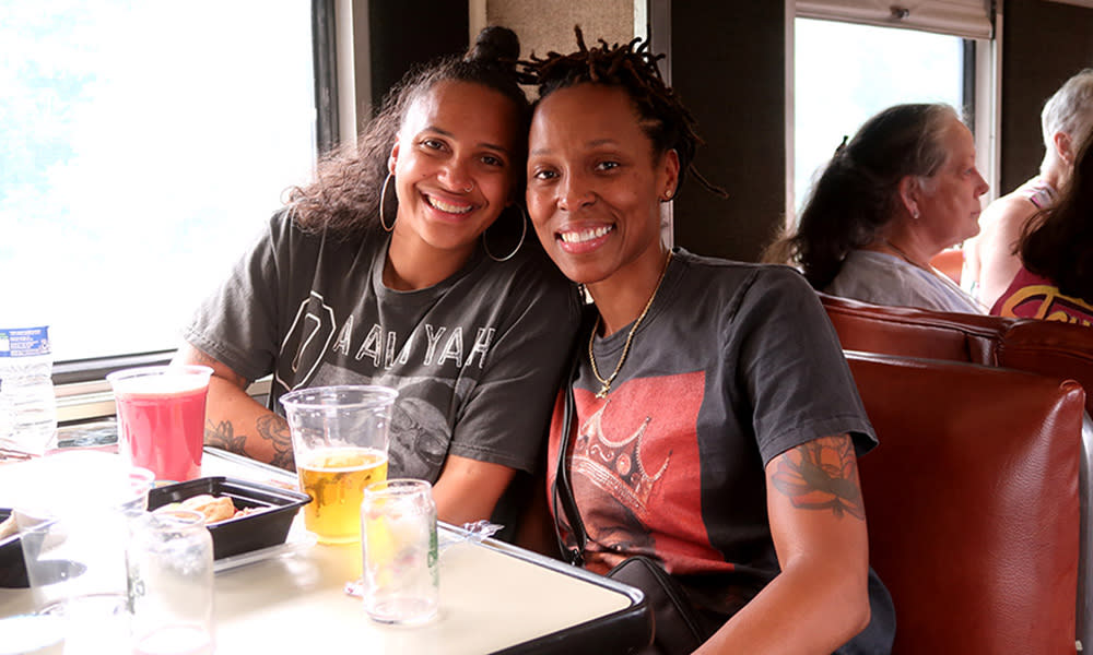 Two women on train at NC Transportation Museum enjoying Brew & Choo.