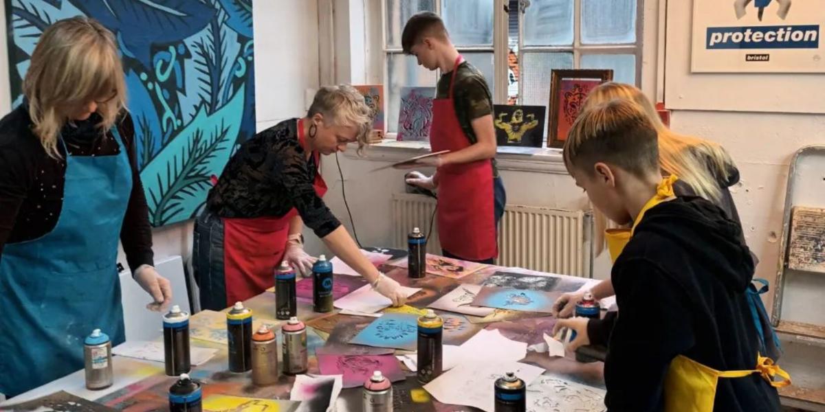 Group spray painting a canvas - credit Yuup / Graft