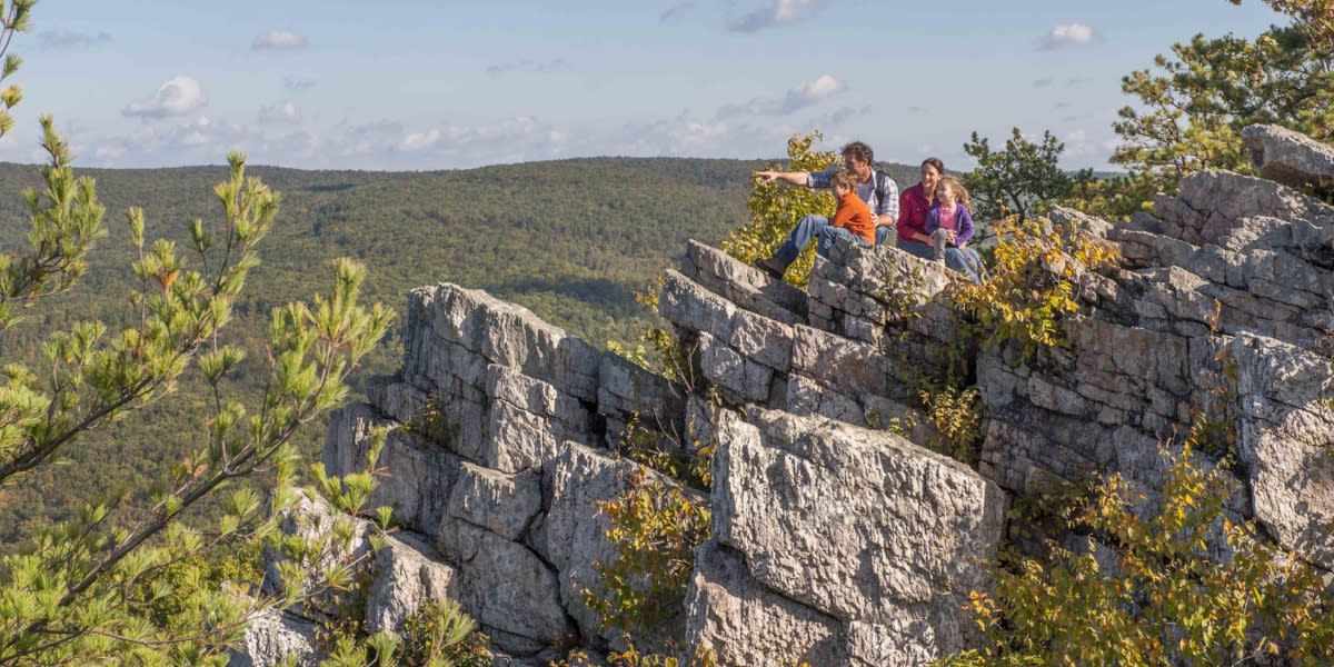 Family sitting on rocks looking at the view on Pole Steeple Trail at Pine Grove Furnace State Park