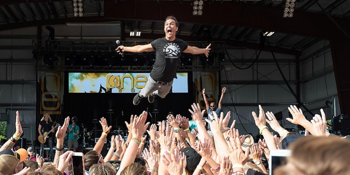A man jumping off the stage at OneFest in Chippewa Falls to crowd-surf