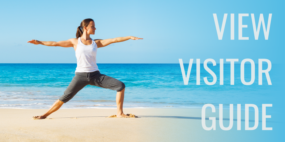 Woman does yoga pose on surf of beach. text to her right reads view visitor guide