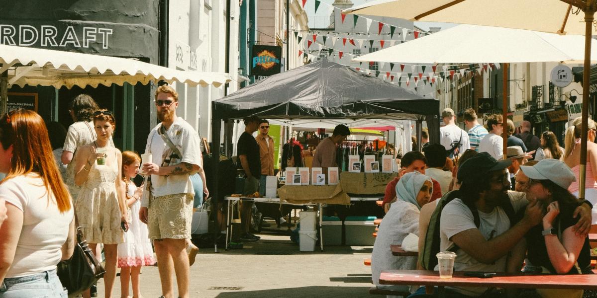 Groups of people enjoying Carlton Place market in pedestrianised area by Overdraft