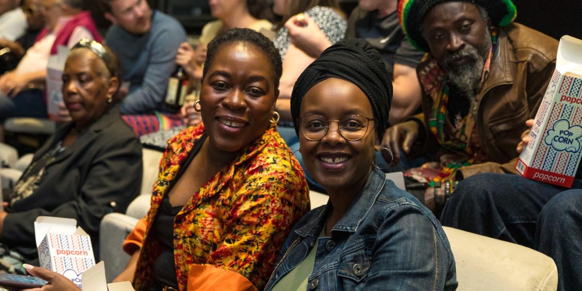 Two women smiling in theatre at Black In Focus event