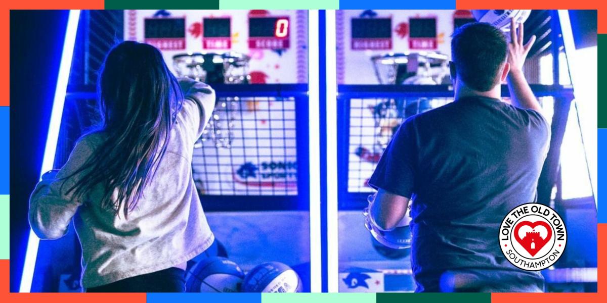 Man and woman shooting hoops, playing a basket ball game at High Score Arcades
