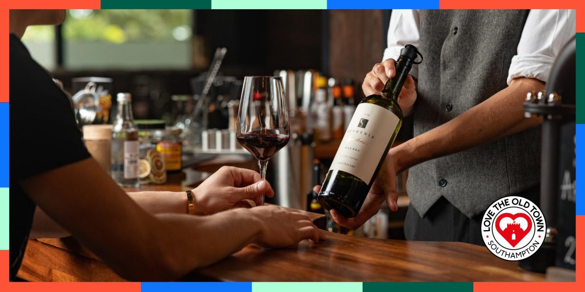 Man holding bottle of wine at Porters