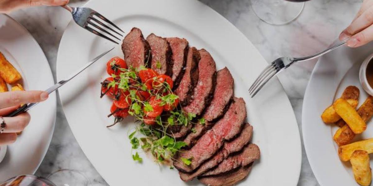 People grabbing beef slices off of plate from Marco Pierre White