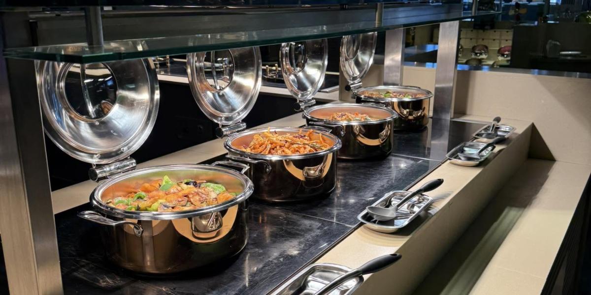 Pan Asian Plaza buffet with big silver pots of noodle dishes and more