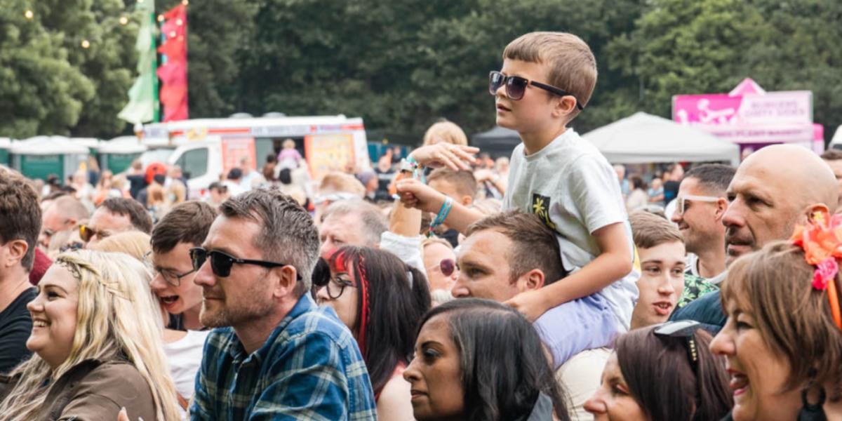 Crowd of people standing by stage to watch a performance