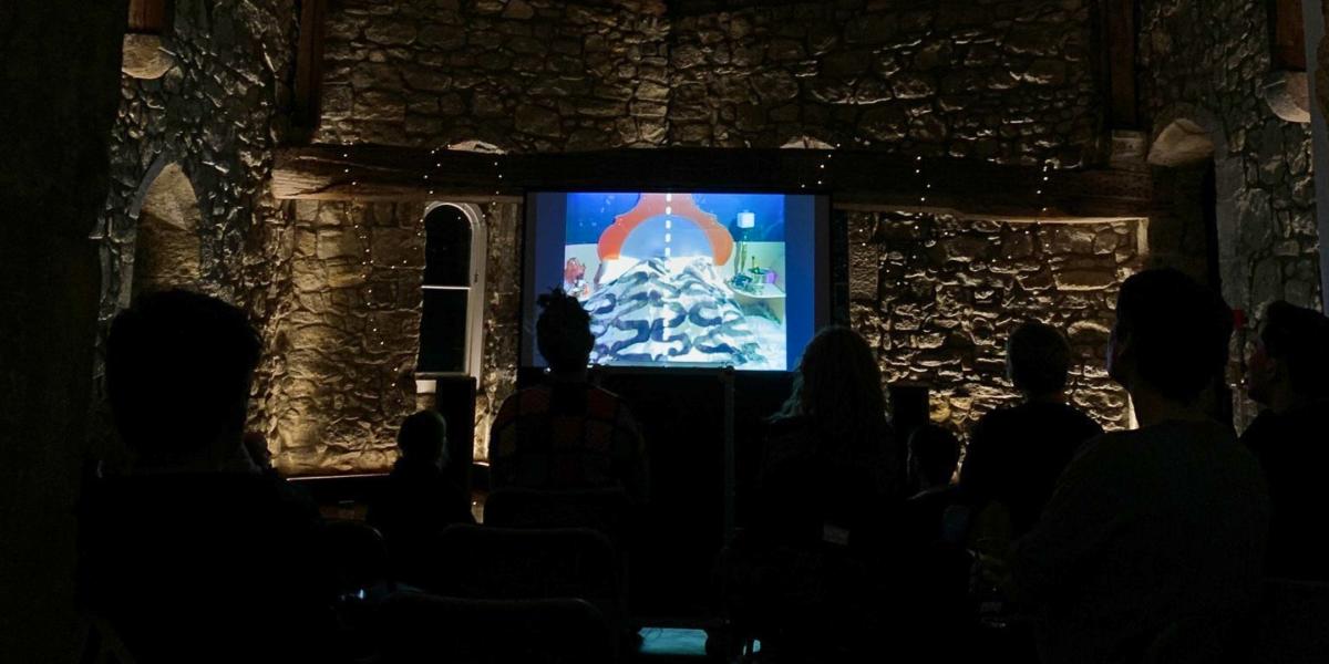 People sat in front of a screen watching a film for This is not a film club at God's House Tower