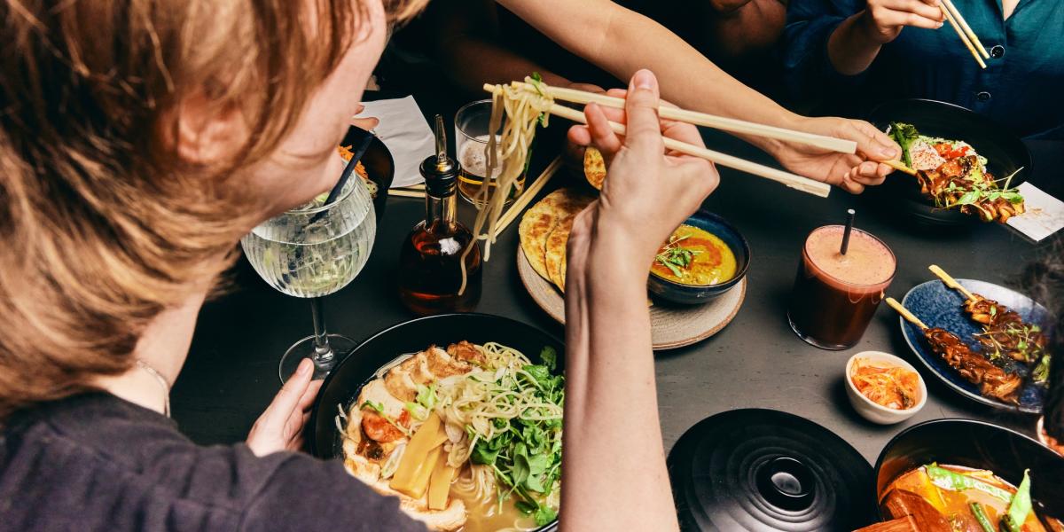 group of friends enjoying warming noodle dishes and small plates from wagamama