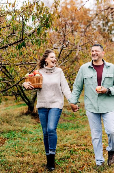 A happy couple walking hand in hand at Jackson's Orchard