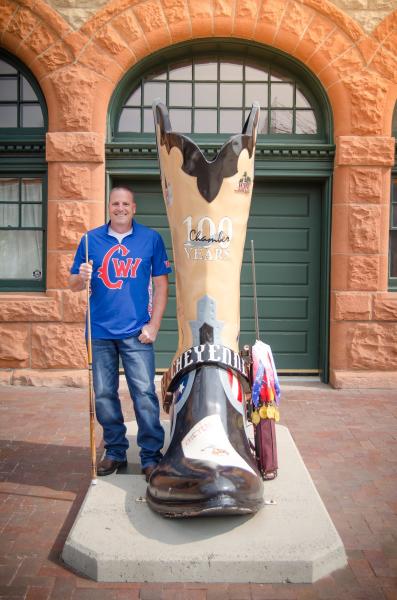 Jon Goodman stands beside one of Cheyenne's Big Boots with his trusty pool cue. 