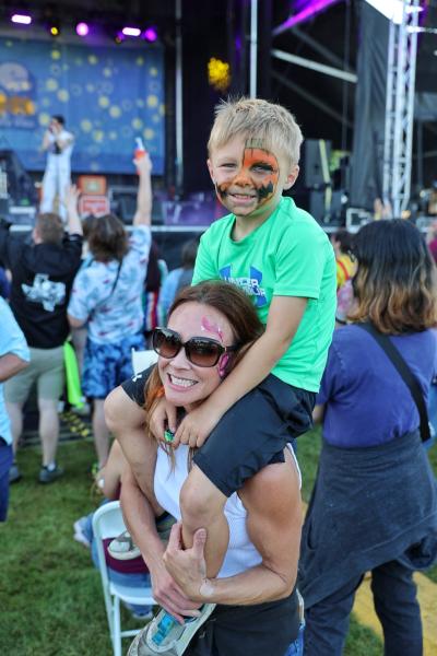 Kid on Mom's Shoulders in front of stage at Taste Addison