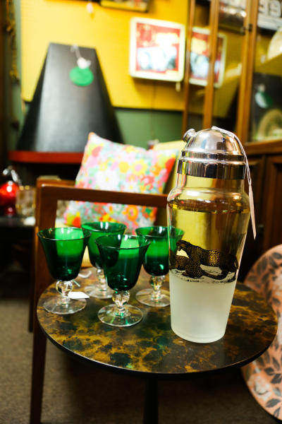 Green glassware and a cocktail shaker with a leopard illustration are on display at Salt City Antiques in Ypsilanti