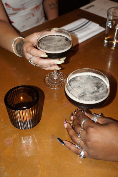 Two female hands holding espresso martinis at Metsi's in Columbus