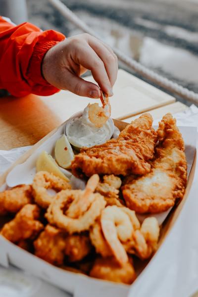 a person eating a fried fish and shrimp basket