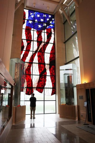A man admiring the stained glass American flag at the Dole Institute.