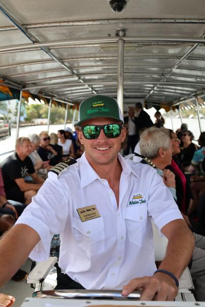 Water Taxi Captain at the helm of a vessel full of passengers