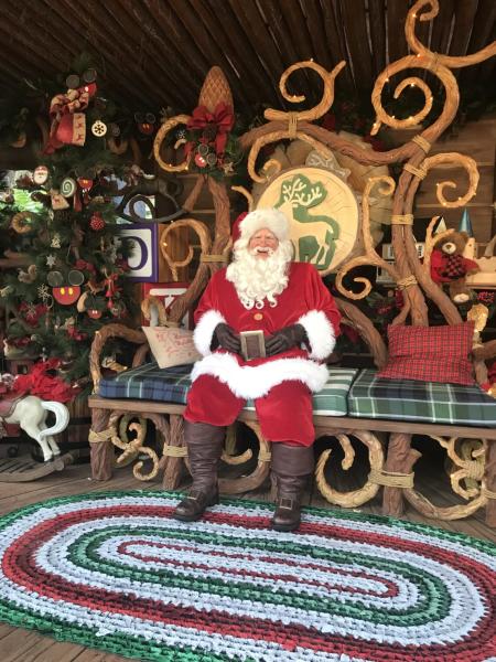 Santa Claus greet visitors while sitting on a festive bench at the Redwood Creek Challenge Trail