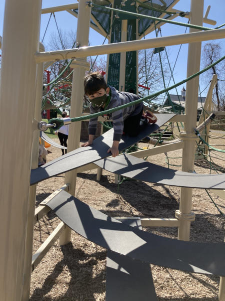 A child climbs a play structure at Kinder Farm.