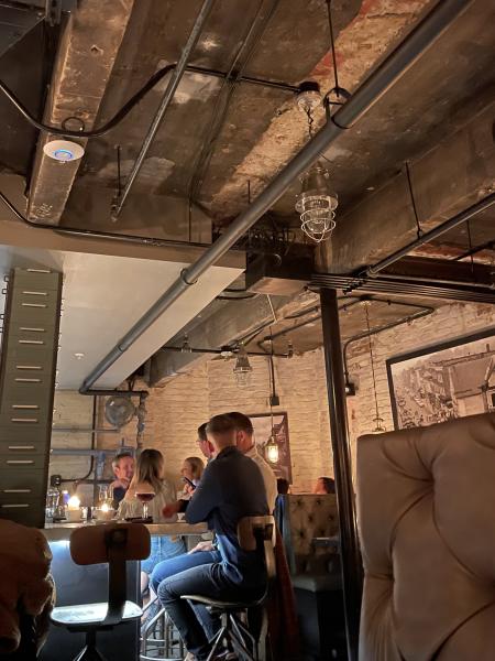 a dark bar underground with wood beams and brick