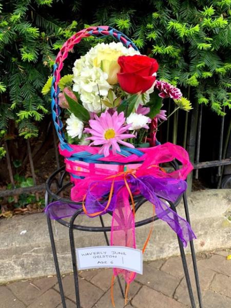 A child's May Day Basket sits on a stool.