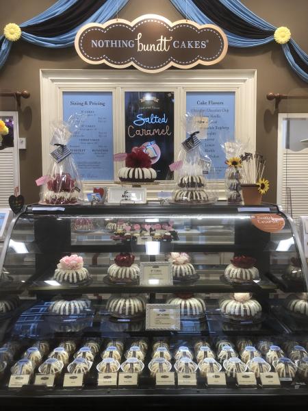 A display case with all size of bundt cakes.