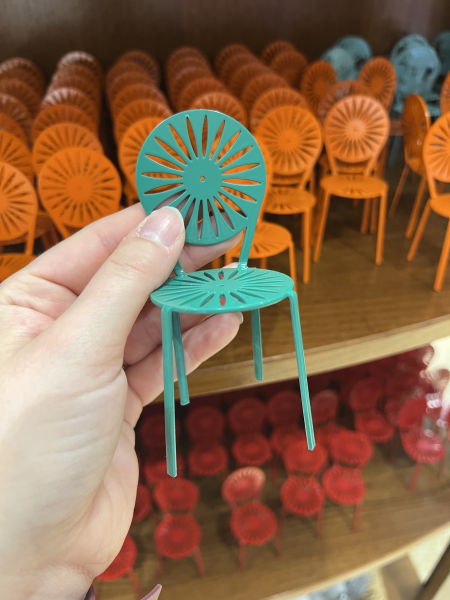 A green mini Terrace chair is held in someone's hand for scale