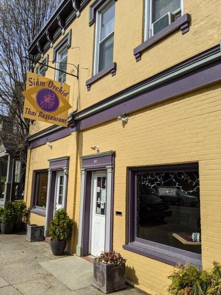 exterior shot of yellow buildling with purple trim and business sign of siam orchid restaurant on historic fairfield avenue in bellevue kentucky