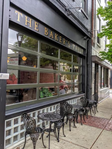 black patio chairs on sidewalk outside of the baker's table restaurant in newport ky