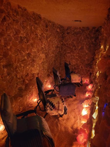 A Salt Cave with four zero-gravity chairs, dimly lit with salt lamps at Soulful Steep