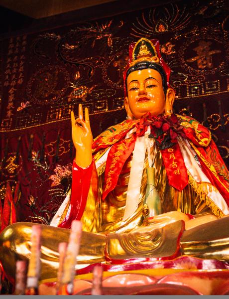 A statue of Buddha on a vibrantly decorated altar