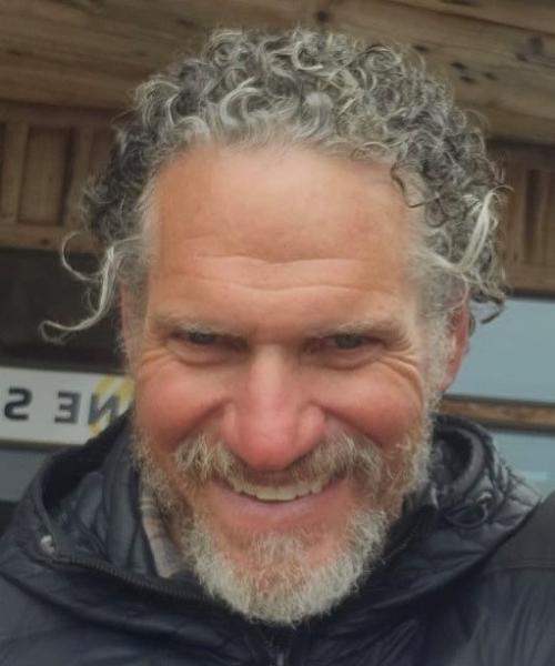 Headshot of a grinning man wearing a rain jacket