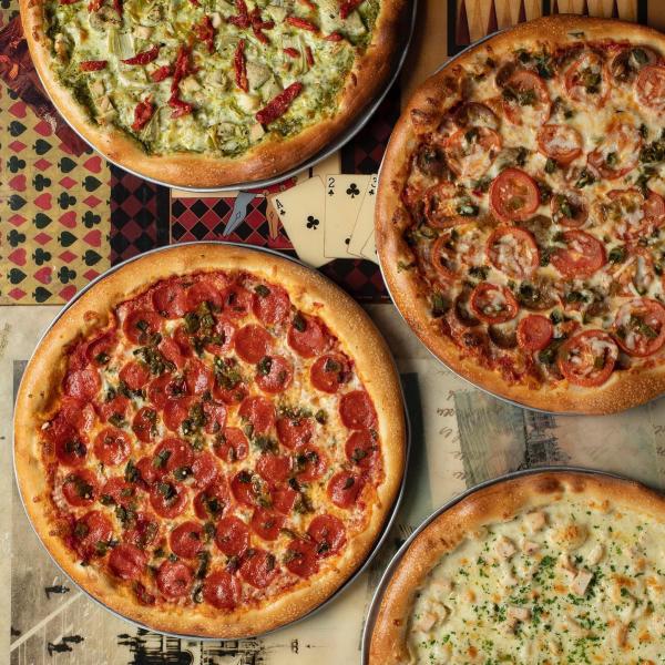 A variety of pizzas sit on a table