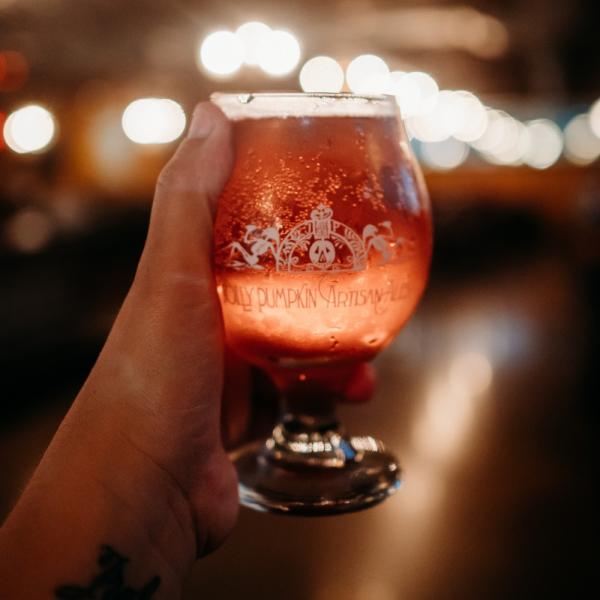 person holding jolly pumpkin beer