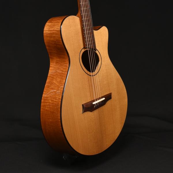 An acoustic guitar sits in a stand
