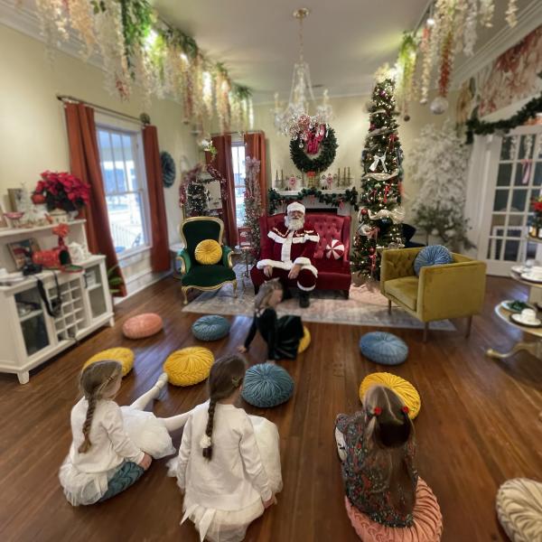 kids sit on the floor in front of Santa