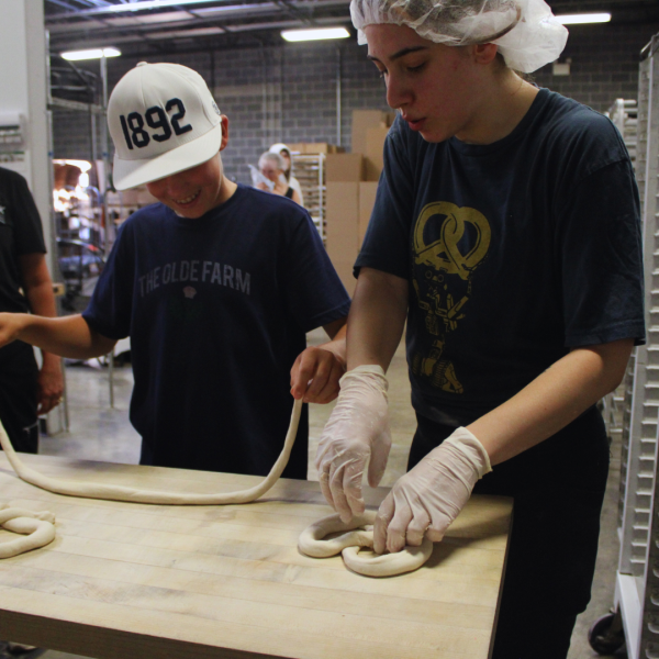 a boy enjoying hand-twisting a pretzel during the Makers Spirit Event