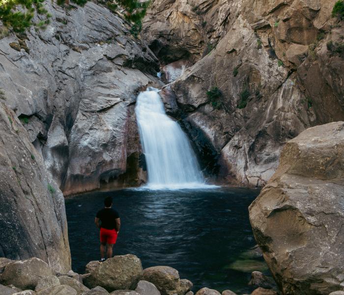 Man faces rushing waterfall in Kings Canyon National Park