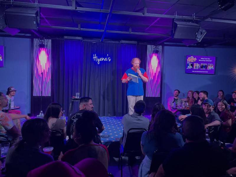 A standup comic performs for an audience at Hyena's Comedy Club.