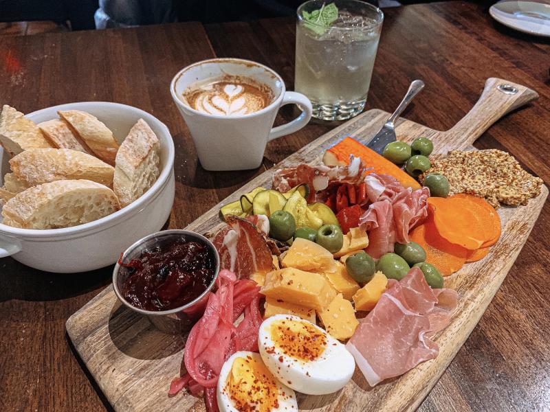 A charcuterie board, latte, and mojito from Feast Market & Cellar