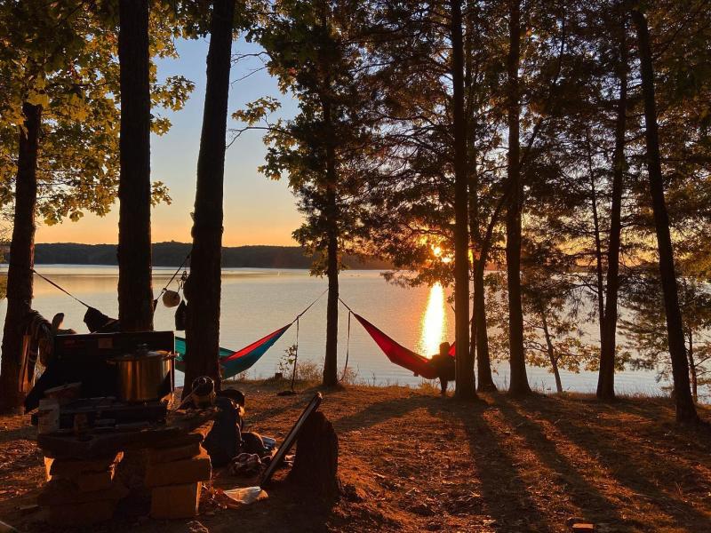A campsite with hammocks hung on the shore of Monroe Lake at the Hoosier National Forest