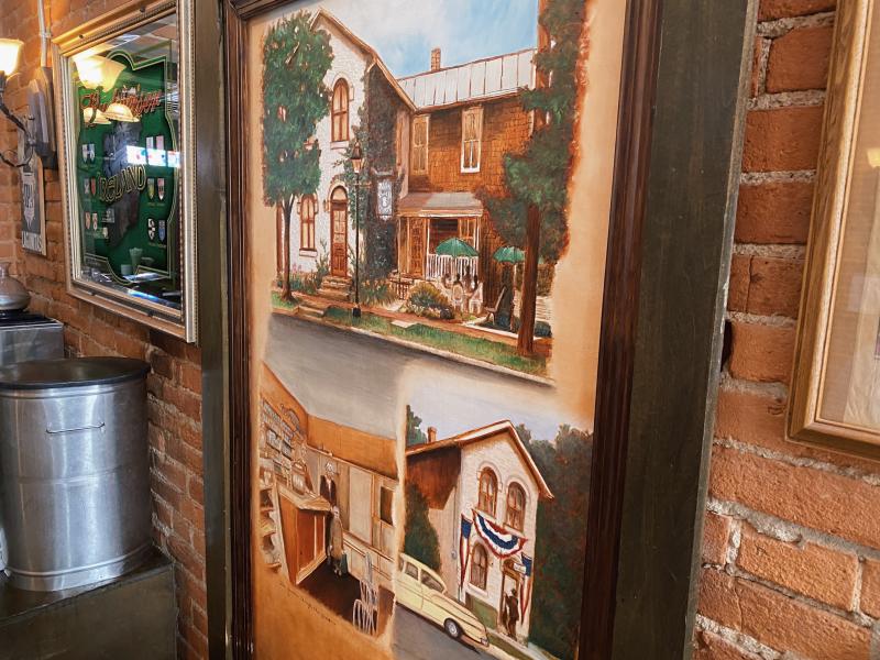 Painting of buildings before the Dublin Village Tavern on brick wall