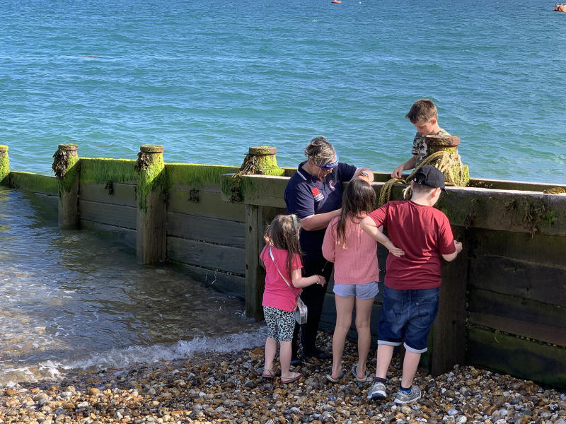 A group of children on a beach with waves coming in