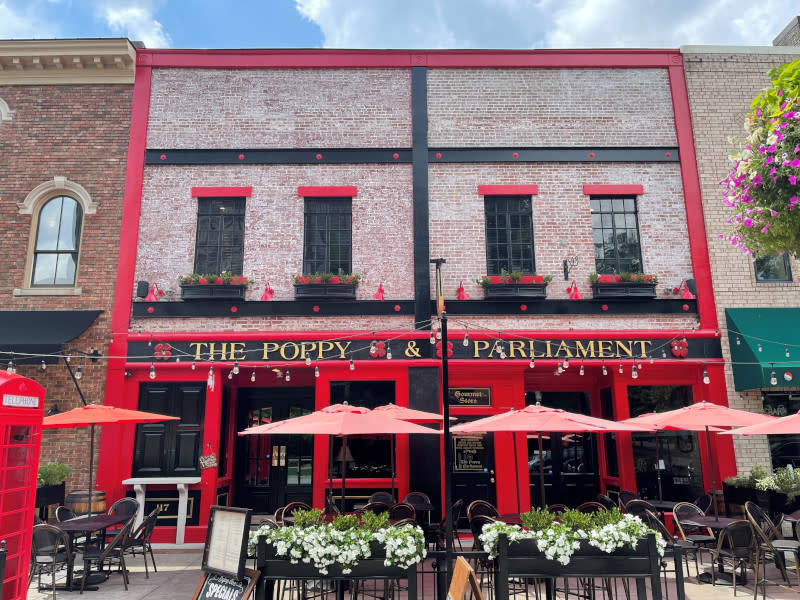 patio outside a restaurant with bright red umbrellas and flowers