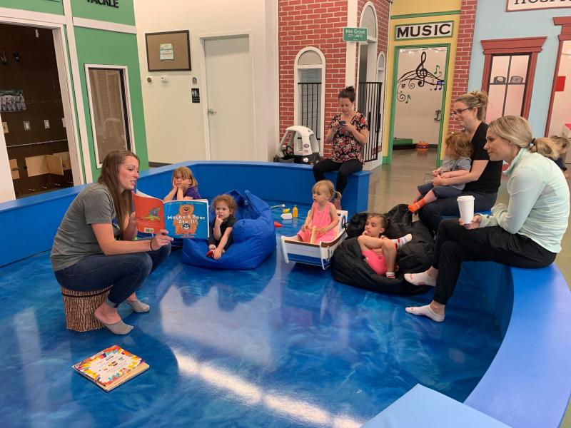 toddlers sit on bean bag chairs listening to story time at MiniSota Play Cafe group