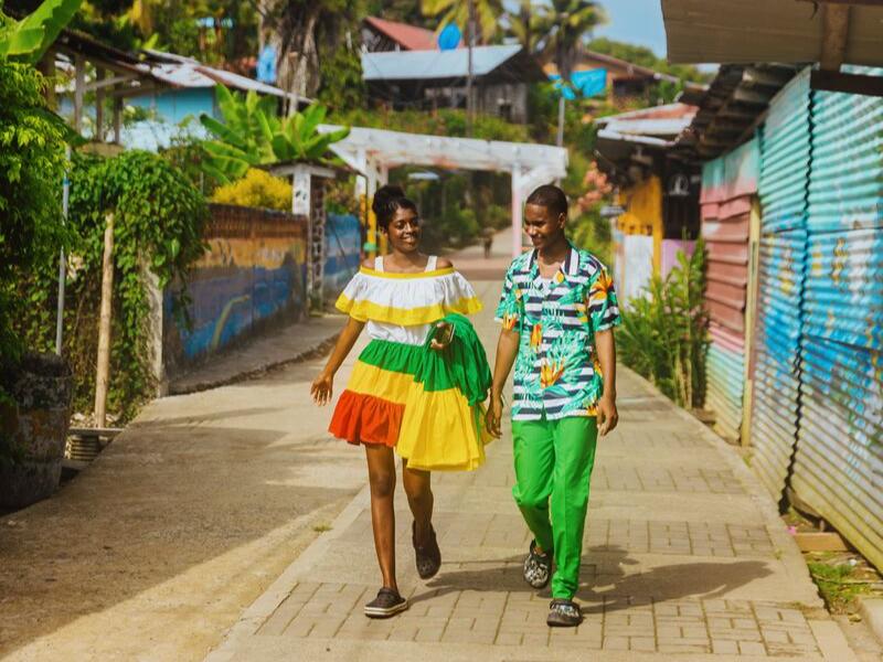 Couple strolling through the colorful streets of Old Bank on Bastimentos Island, Panama.