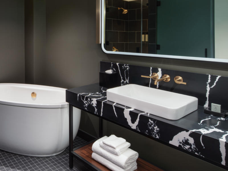 Freestanding tub and bathroom vanity with mirror and towels