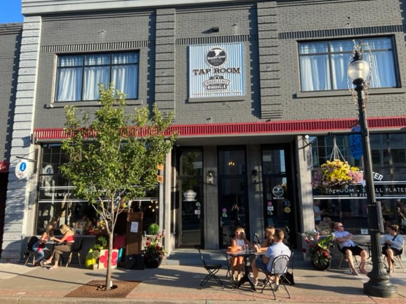 outside of brewery with people enjoying beer on tables