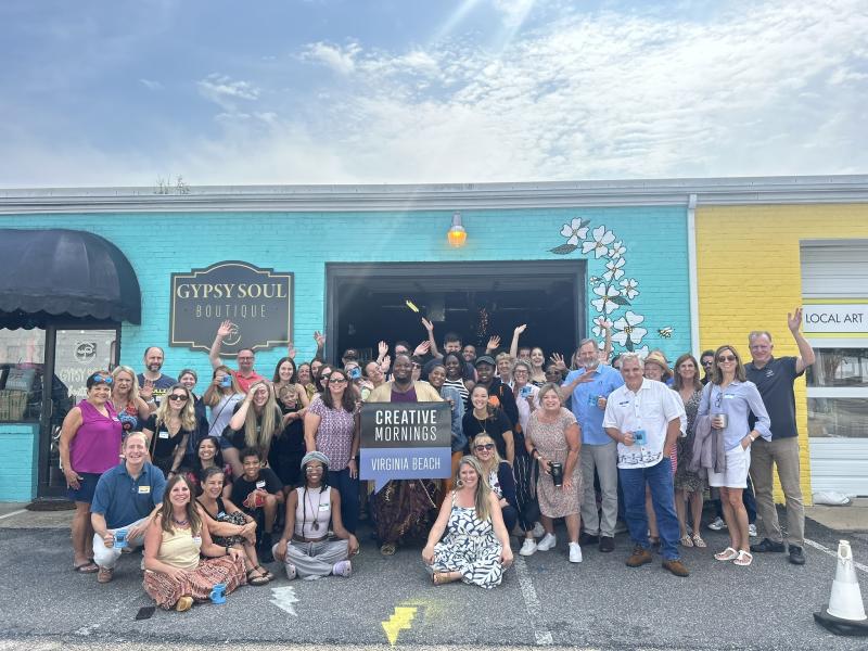 Group taking a photo for event in front of business.